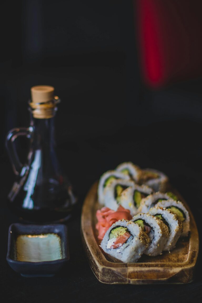 Artistic sushi rolls with soy sauce and wasabi in a restaurant setting.